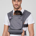 Man carries baby on his chest in Izmi Baby Carrier with Zip Pocket attached