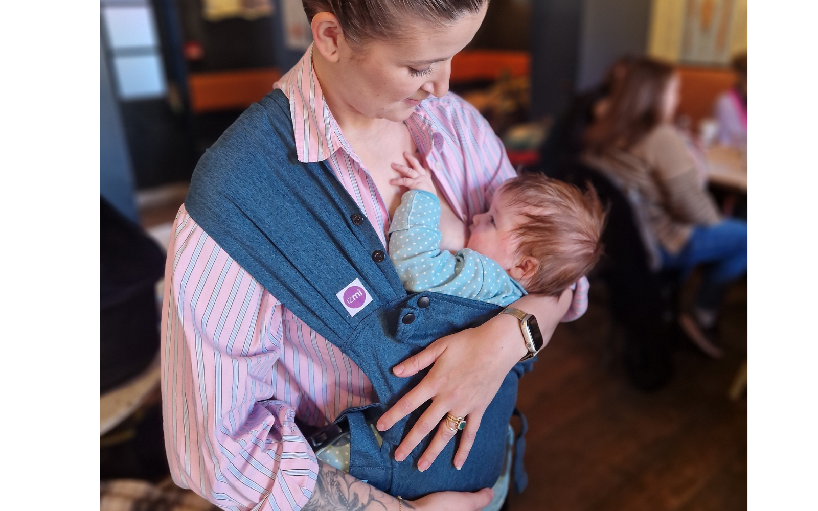 How to safely breastfeed in a baby carrier: here's what you need to know. Here is a mum breastfeeding a 4 month old baby in an Izmi Essential Carrier