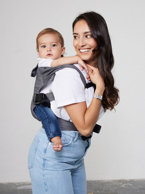Woman carries baby on her back in Izmi Breeze Baby Carrier