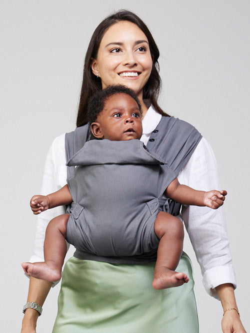 Woman carries baby facing forwards in Izmi Baby Carrier