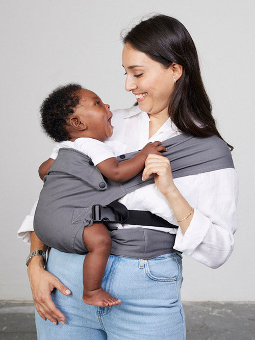 Woman carries baby on her hip in Izmi Baby Carrier