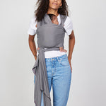 Woman carries baby facing towards her in Izmi Baby Wrap in Grey colour