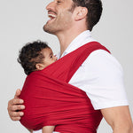 Man carries baby facing towards him in Izmi Baby Wrap in Red