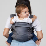 Woman carries baby on her back in Izmi Breeze Baby Carrier, back view