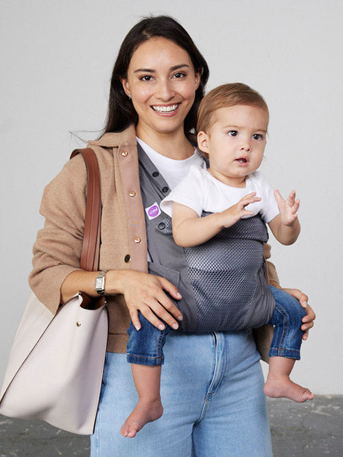 Woman carries baby facing forwards in Izmi Breeze Baby Carrier