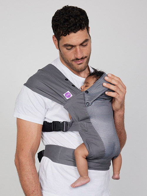 Man carries baby on his chest in Izmi Breeze Baby Carrier