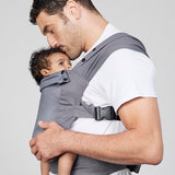 Man carries baby facing towards him in Izmi Breeze Baby Carrier, side view