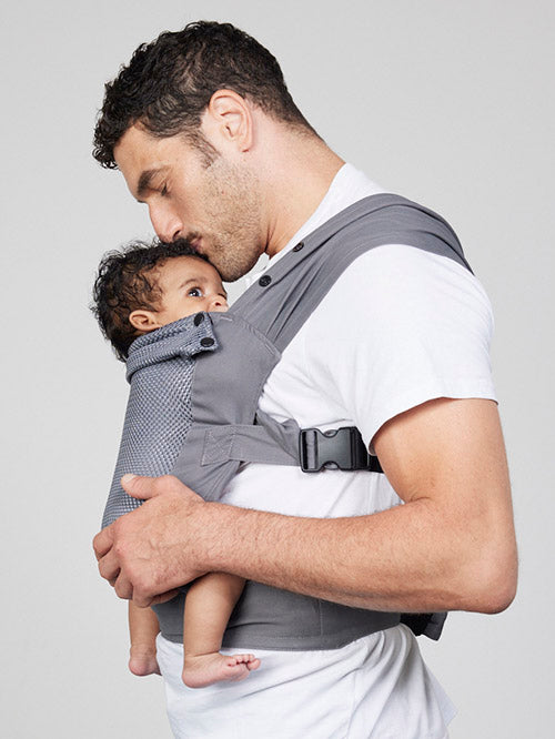 Man carries baby facing towards him in Izmi Breeze Baby Carrier, side view