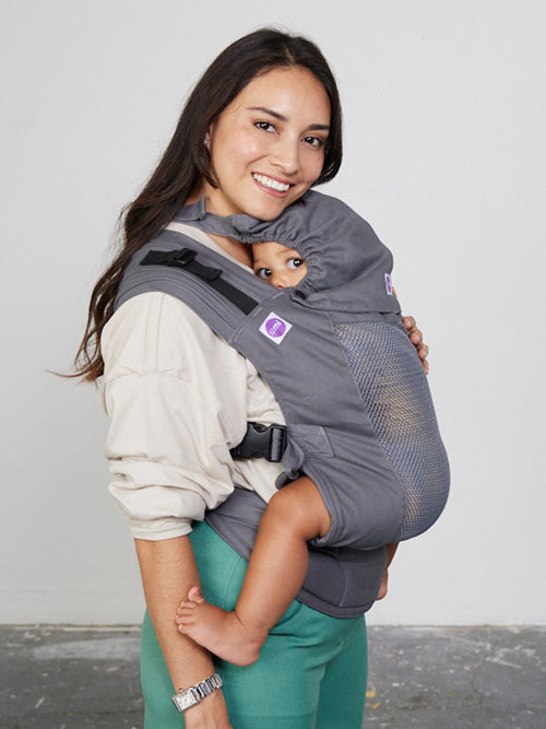 Woman carries toddler on her front in Izmi Breeze Baby Carrier with Sleep Hood