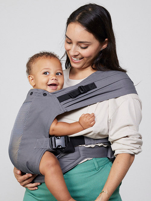 Woman carries baby on her hip in Izmi Breeze Toddler Carrier