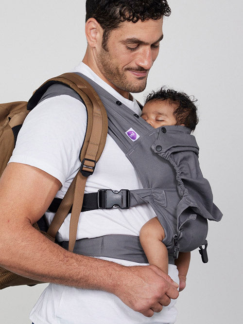 Man carrying baby on his front in Izmi Baby Carrier with attached Sleep Hood