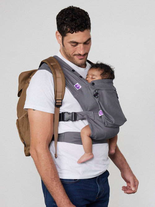Man carries baby on his chest in Izmi Baby Carrier with Zip Pocket attached