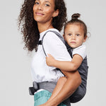 Woman carries toddler on her back in Izmi Toddler Carrier