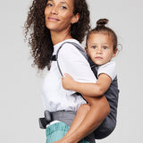 Woman carries toddler on her back in Izmi Toddler Carrier