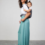 Woman carries toddler on her back in Izmi Toddler Carrier