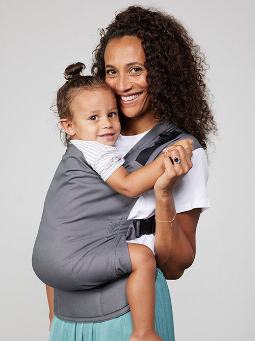 Woman carries toddler on her front in Izmi Toddler Carrier