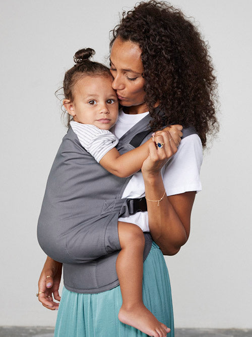 Woman carries toddler on her front in Izmi Toddler Carrier
